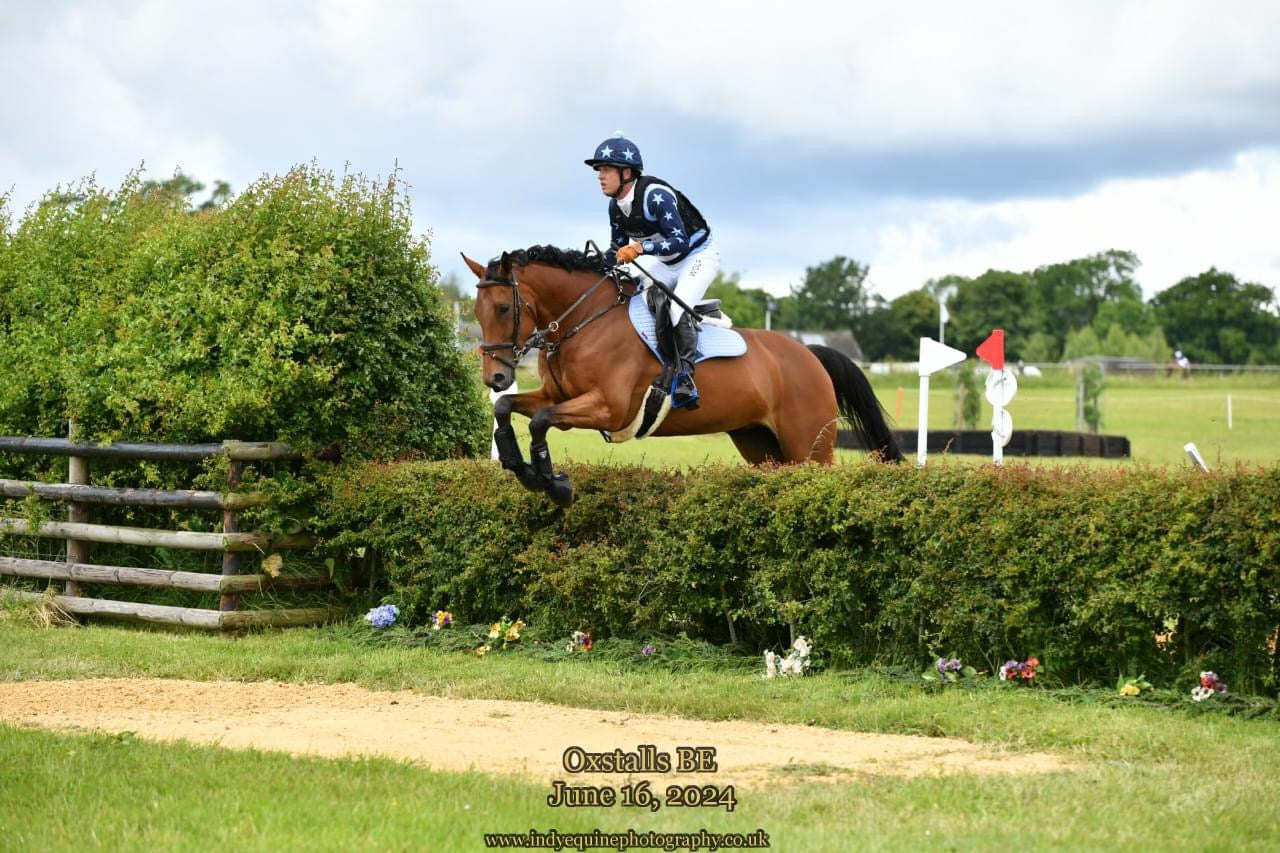 Men riding a horse jumping a XC fence wearing Wolf Equestrians Men's White Competition Breeches
