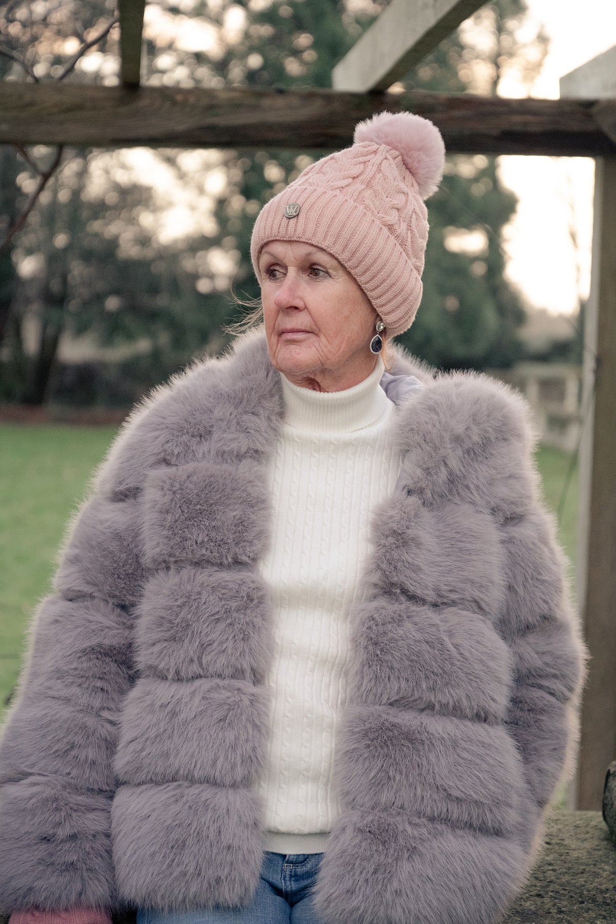 Women's Grey Faux Fur Coat while wearing a Pink Hat